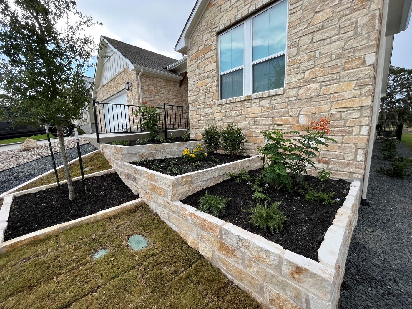 A Pioneer install: limestone bed work with new plantings set against the house